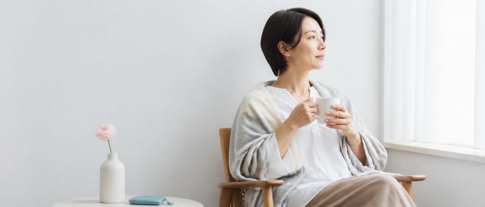 光の入る部屋で心を落ち着ける女性