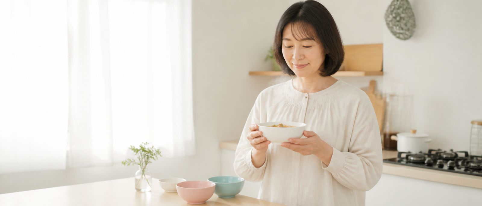 明るいキッチンでスープを持つ女性